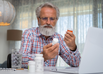 Man looking at his prescription bottle.